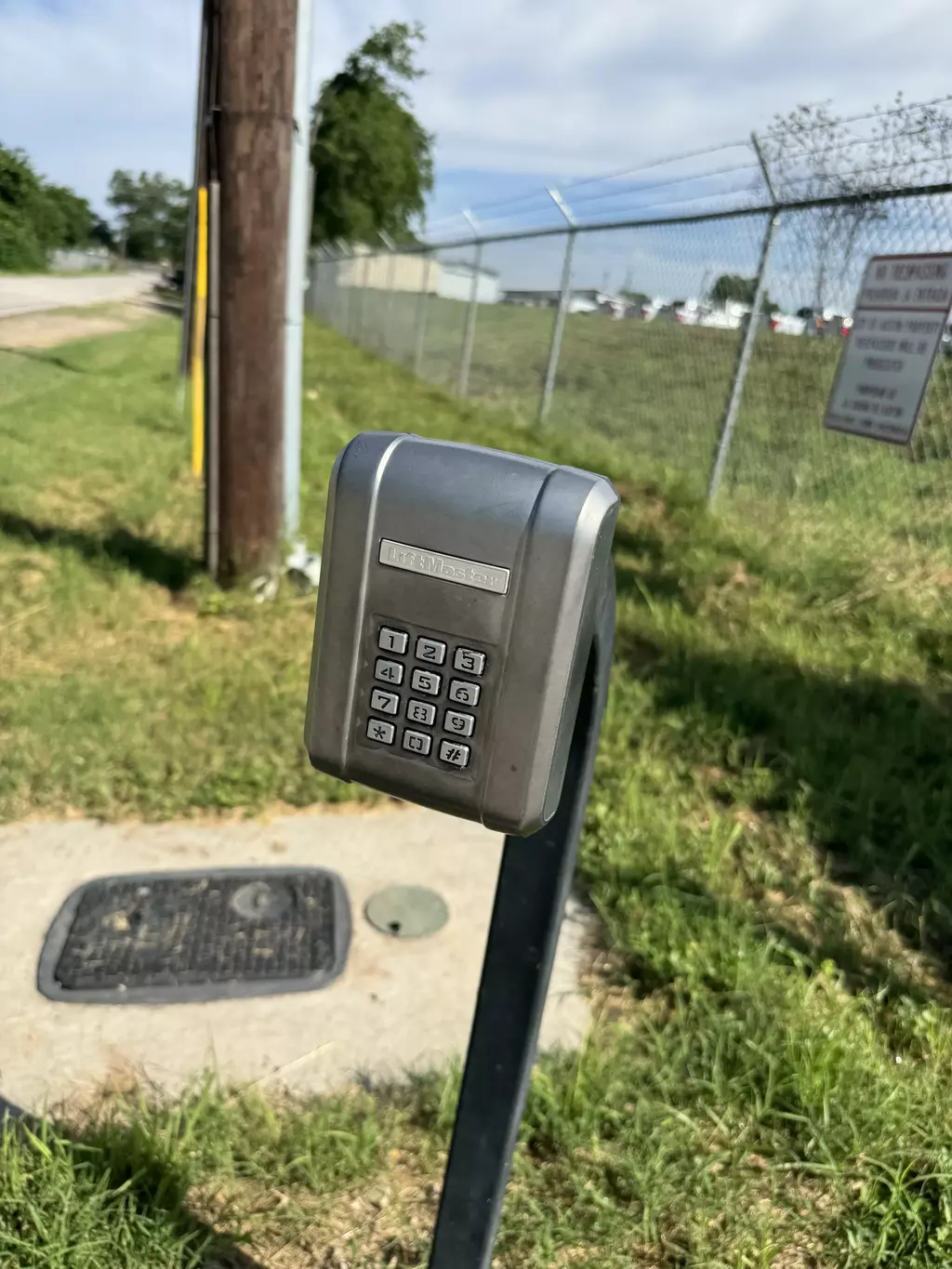 open gray automatic gate with stone facade posts