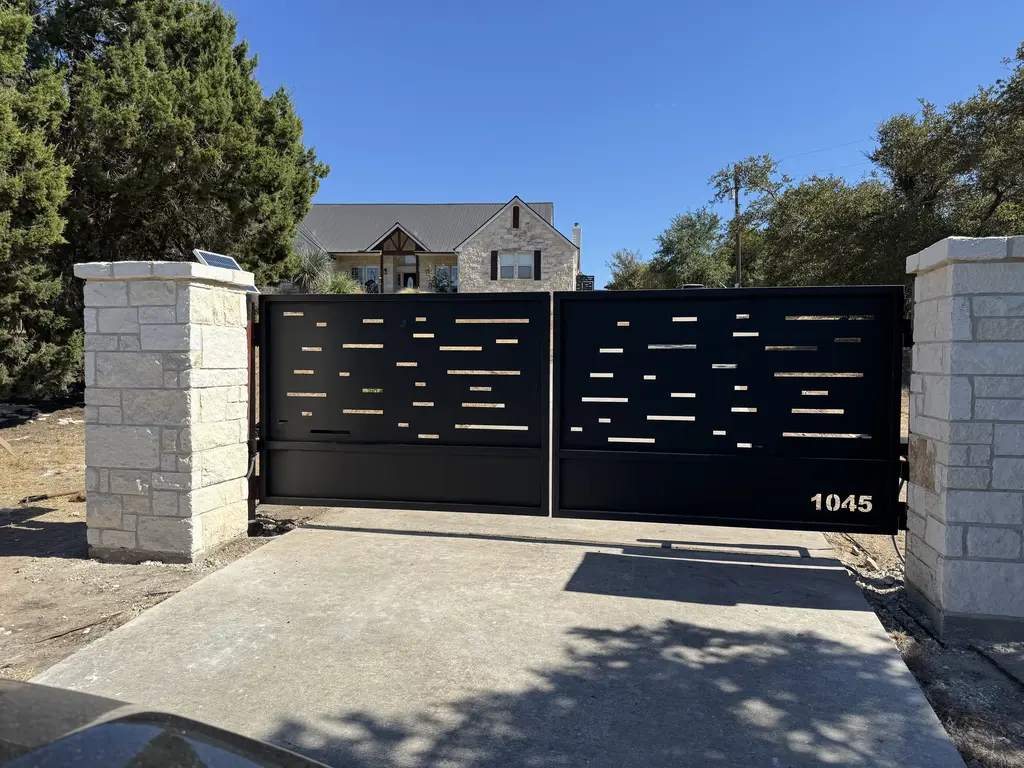 open gray automatic gate with stone facade posts